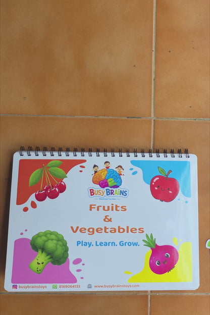 Toddler flipping through Busy Brains Fruits and Vegetables Activity Binder with Montessori learning pages