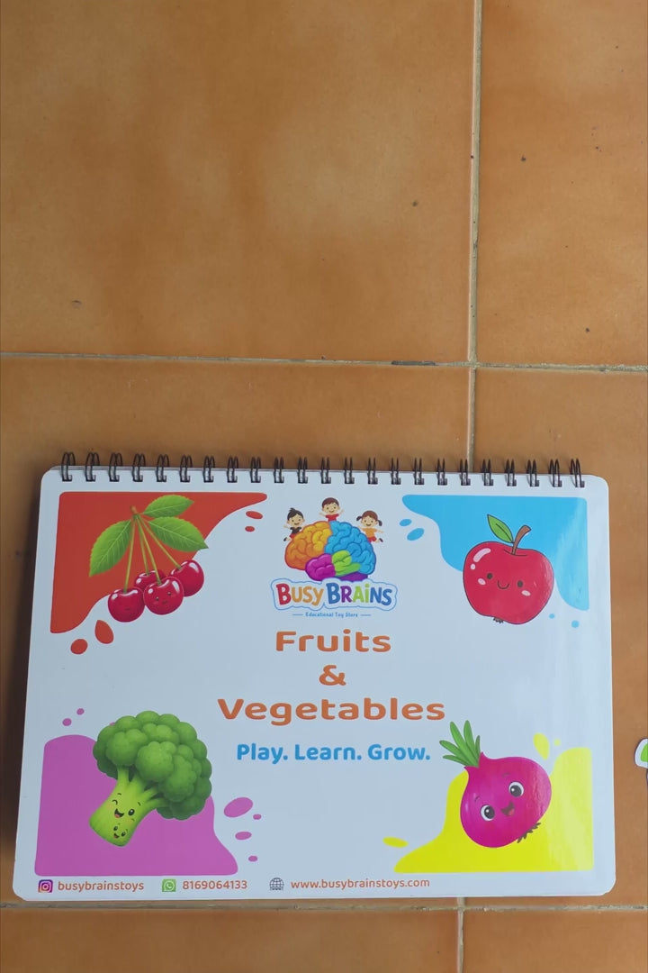 Toddler flipping through Busy Brains Fruits and Vegetables Activity Binder with Montessori learning pages