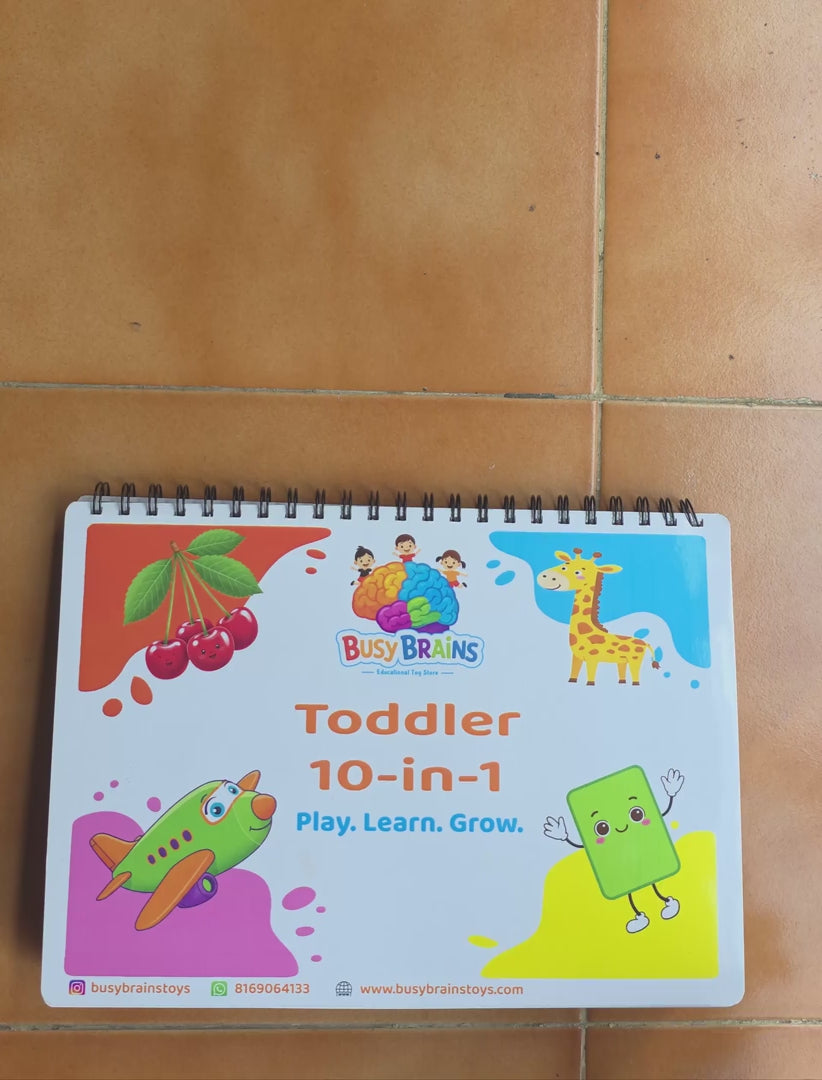 Toddler flipping through Busy Brains Activity Binder with all in one Montessori learning pages