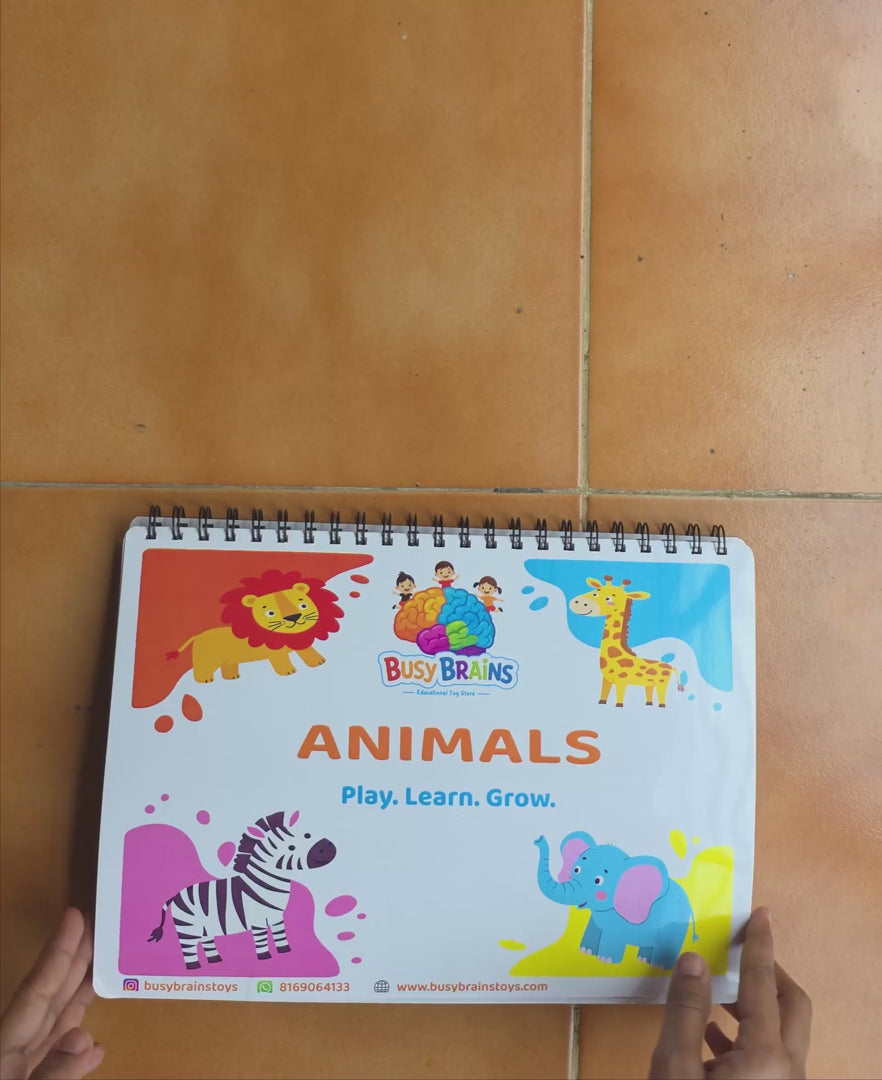 Toddler flipping through Busy Brains Animals Activity Binder with sea animals Montessori learning pages